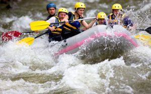 A group of people maneuver a white water raft through a turbulent river outside of Leavenworth, WA.