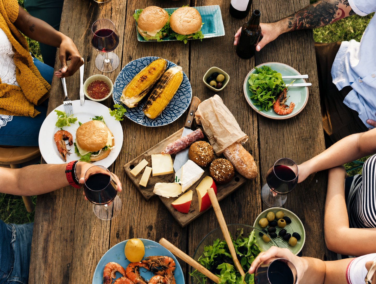Friends sharing a meal around a rustic outdoor table